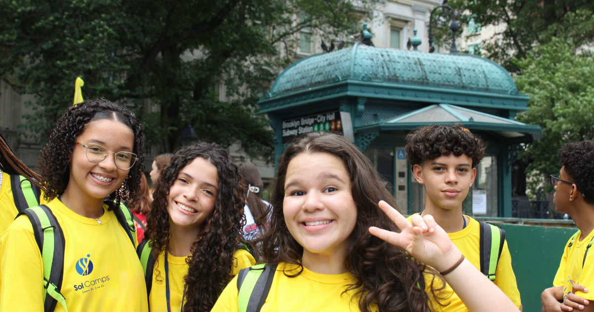 Sol Camps New York campers in yellow camp T-shirts smiling on a New York City street
