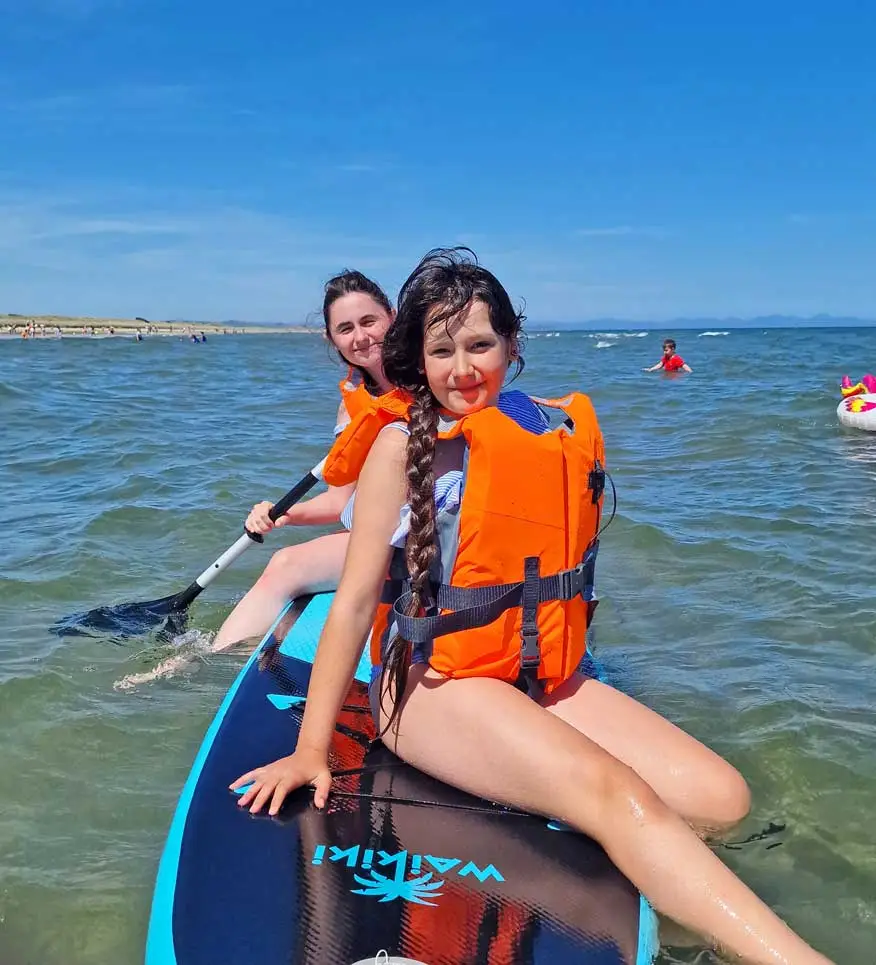 Camp students in life jackets paddling together on the sea during a water activity