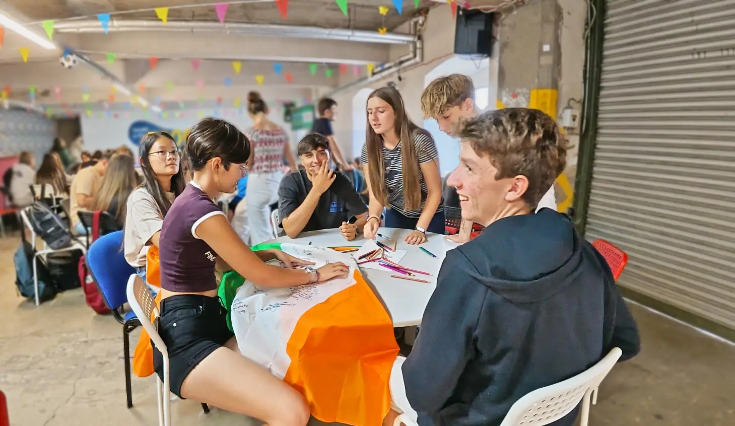 Camp students around a table decorated with bunting and an Irish flag during an evening social event