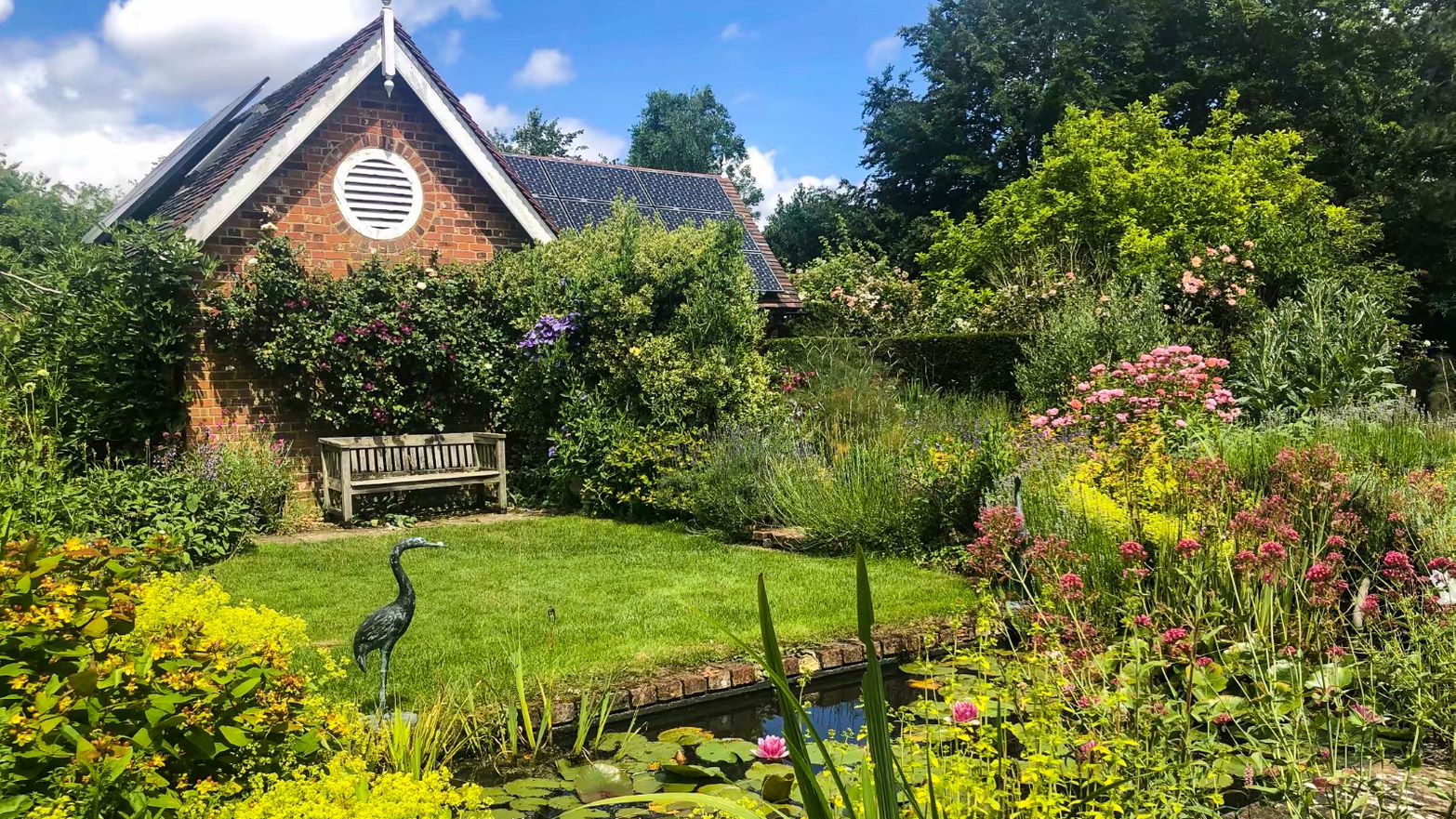 Garden of a Select English host family home with lawn, flower beds and a bench