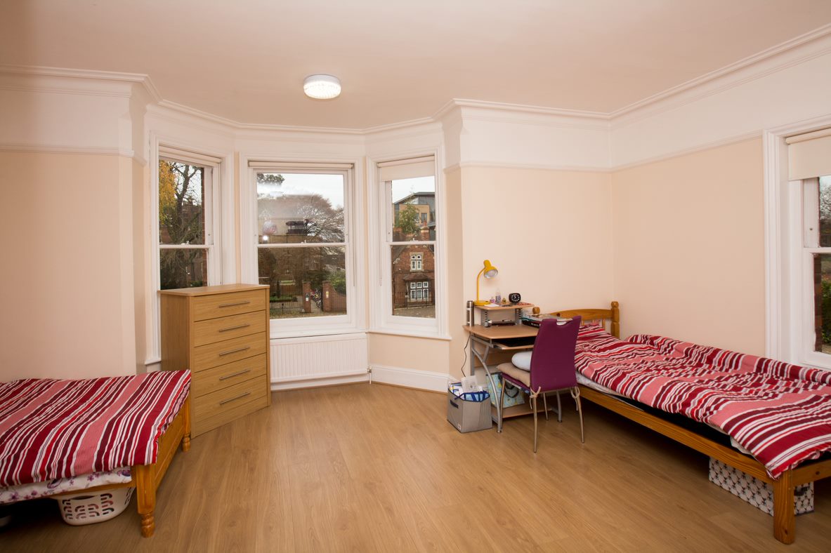 Twin bedroom in a Select English residence with two beds, striped bedspreads and a bay window