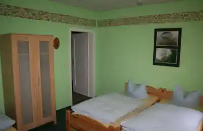 Simple room with beds and a wardrobe in the accommodation at Lake Stechlin