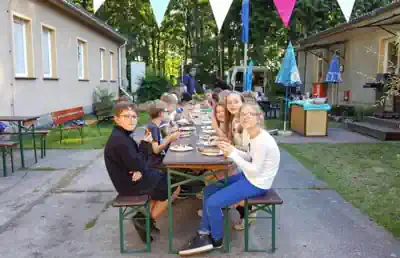 Children having breakfast at a long outdoor table at the Lake Stechlin dive camp