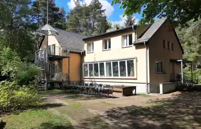 Exterior of Villa Frida in Wandlitz with its terrace, surrounded by pine trees