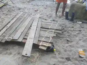 Wooden planks lashed together with rope during raft building at the Villa Frida film camp