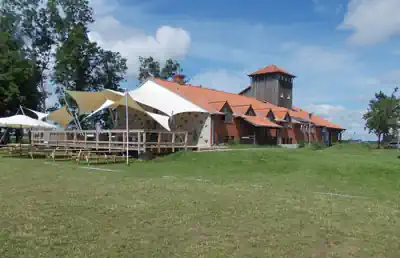 Main building of Sporthostel Schubybeach with sun sails and terrace