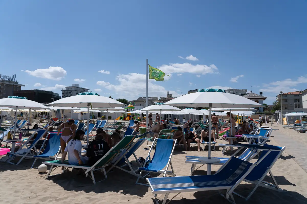 Rows of sun loungers and parasols on the operator’s section of beach, with the seafront behind