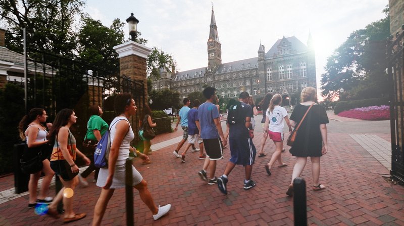 High school students walking through the gates towards Healy Hall on the Georgetown University campus