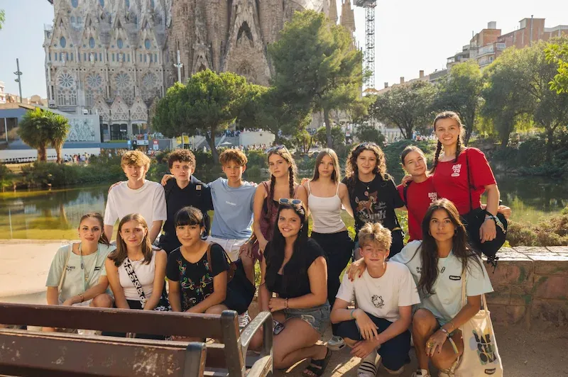 A group of Expanish summer camp students pose together during a walking tour in Barcelona, with the Sagrada Familia in the background.