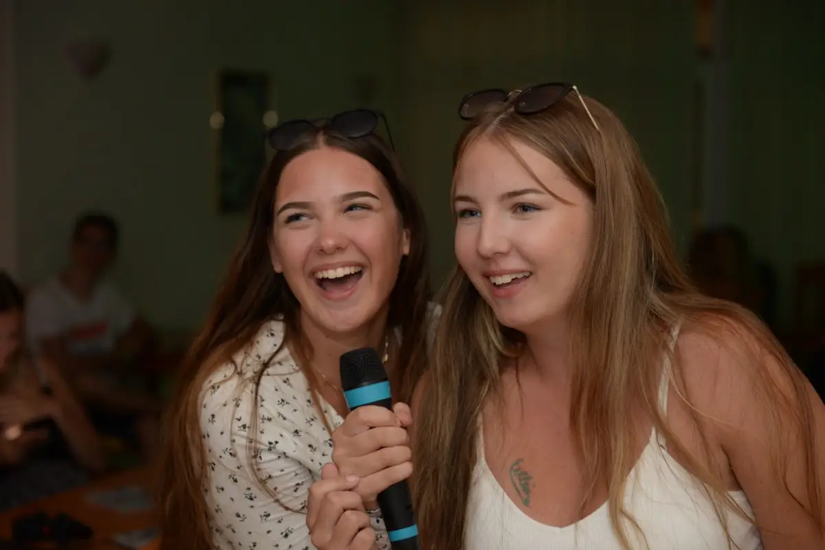 Two participants singing into a microphone at the karaoke party
