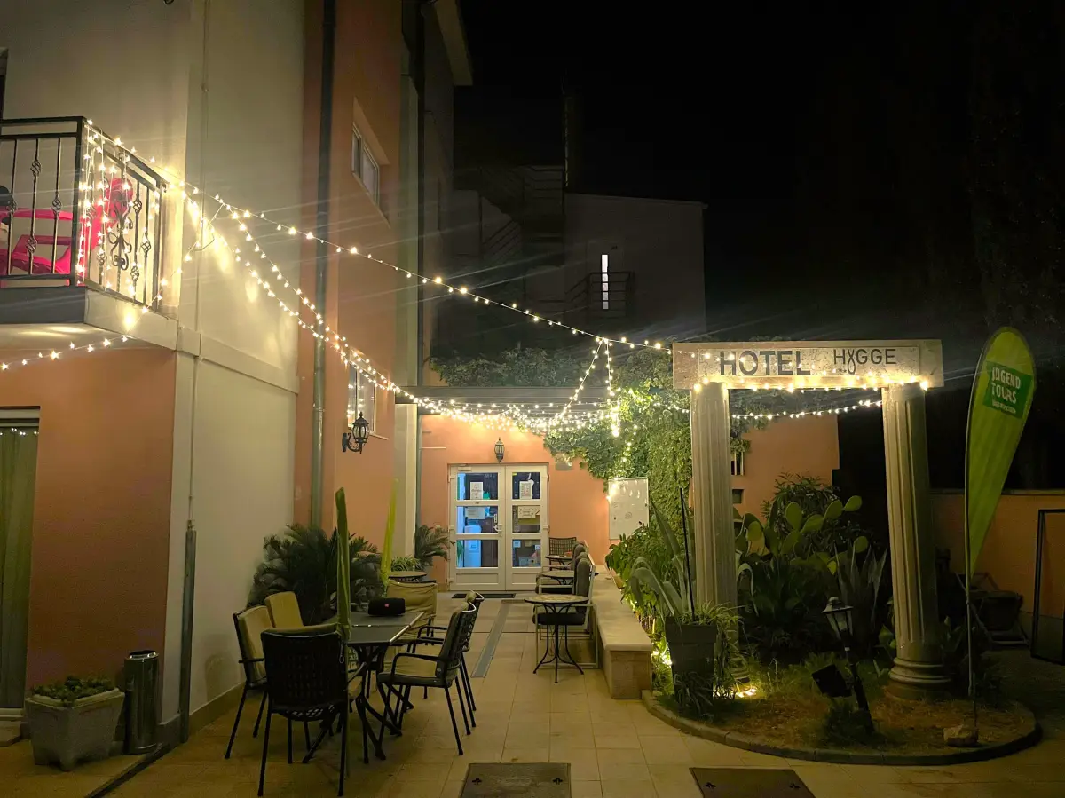 Hotel terrace in the evening strung with fairy lights, tables and chairs set out