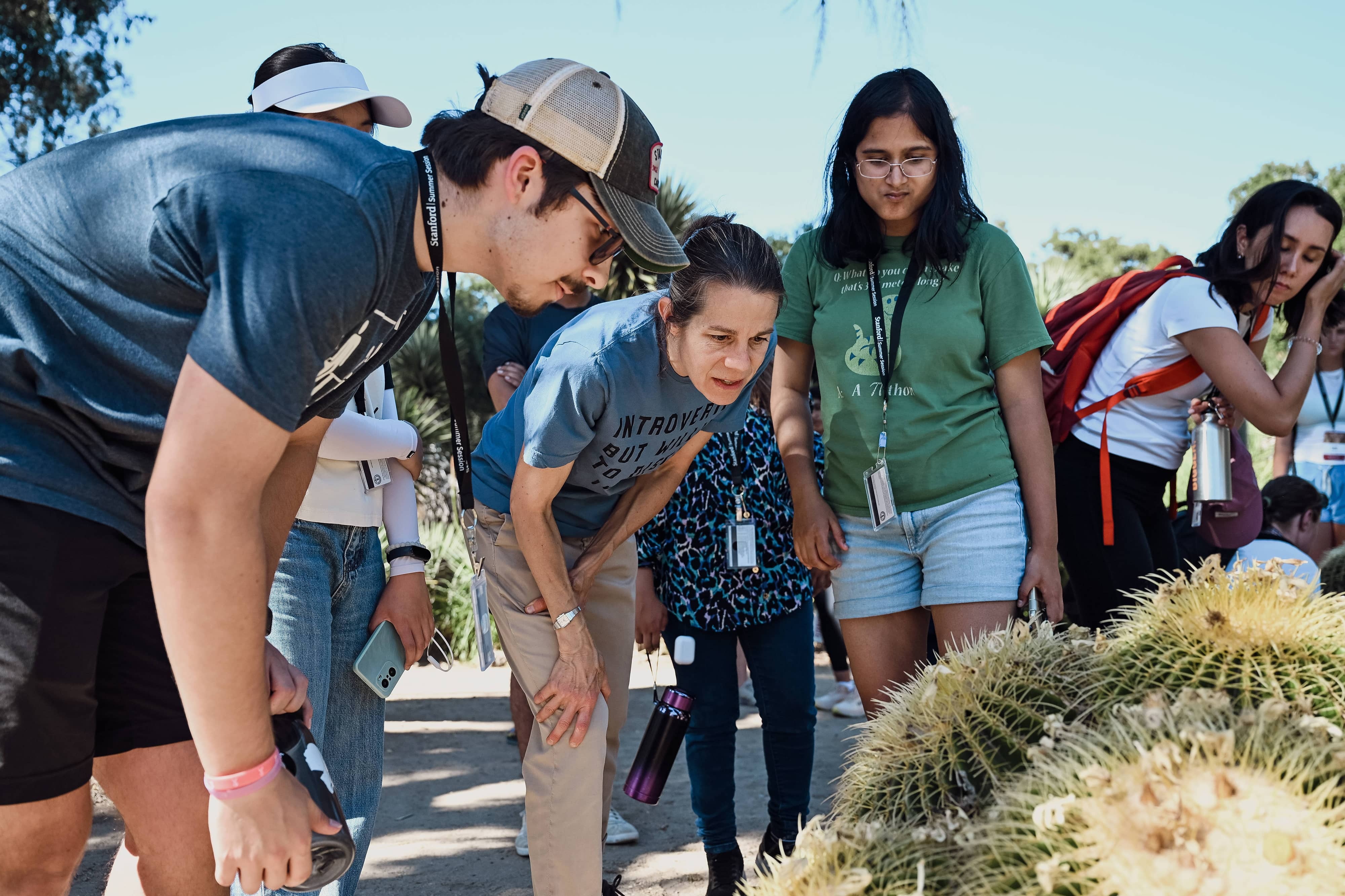 A group of students walking among cacti and succulents on a guided tour of the Arizona Garden on the Stanford campus.