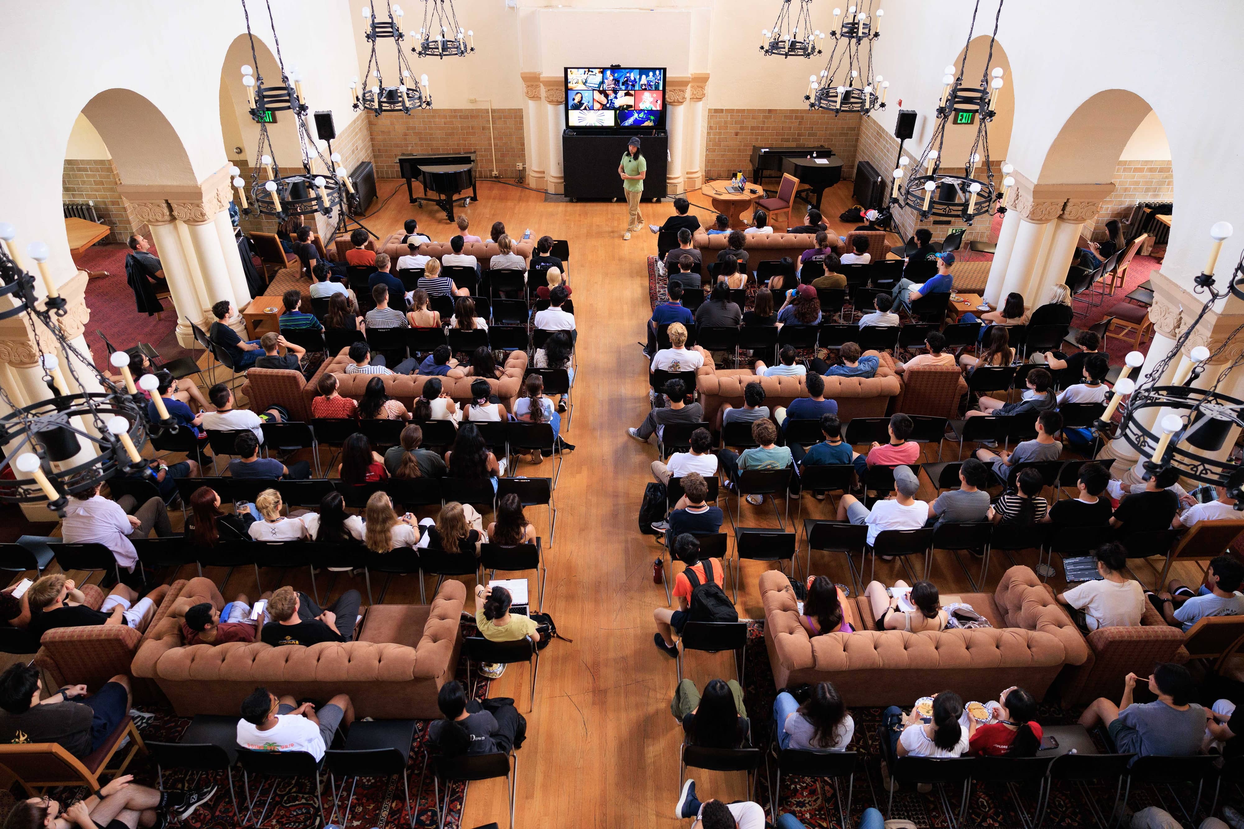 A full lecture hall of Summer Session students facing a speaker on the stage below.