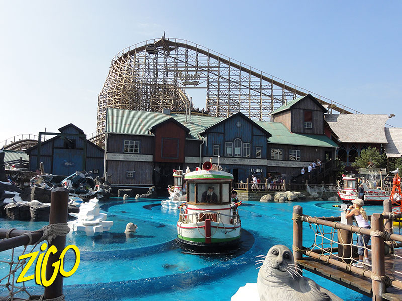 Wooden buildings and the seal pool of the Scandinavian themed quarter at Europa Park, timber coaster behind