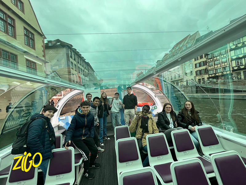 Participants aboard a glass-roofed sightseeing boat on the canals of the historic centre of Strasbourg