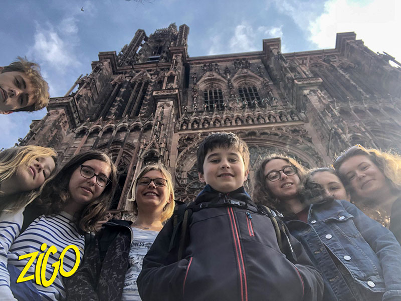 Group of participants in front of the red sandstone facade of the cathedral of Notre-Dame in Strasbourg