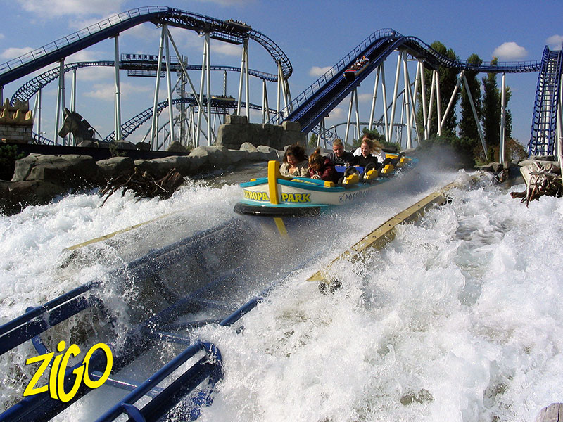 Boat of a water ride hitting the splash pool at Europa Park, roller coaster track above