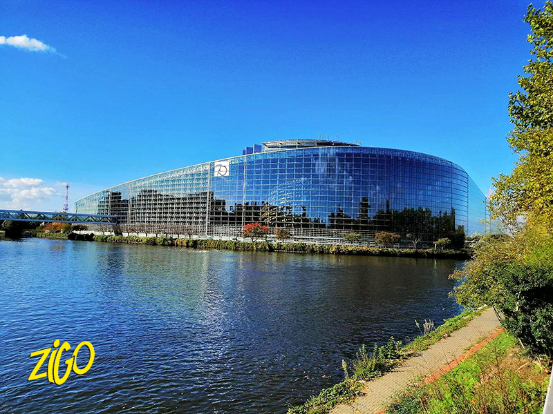 The glass and steel European Parliament building in Strasbourg seen across the water on a clear day