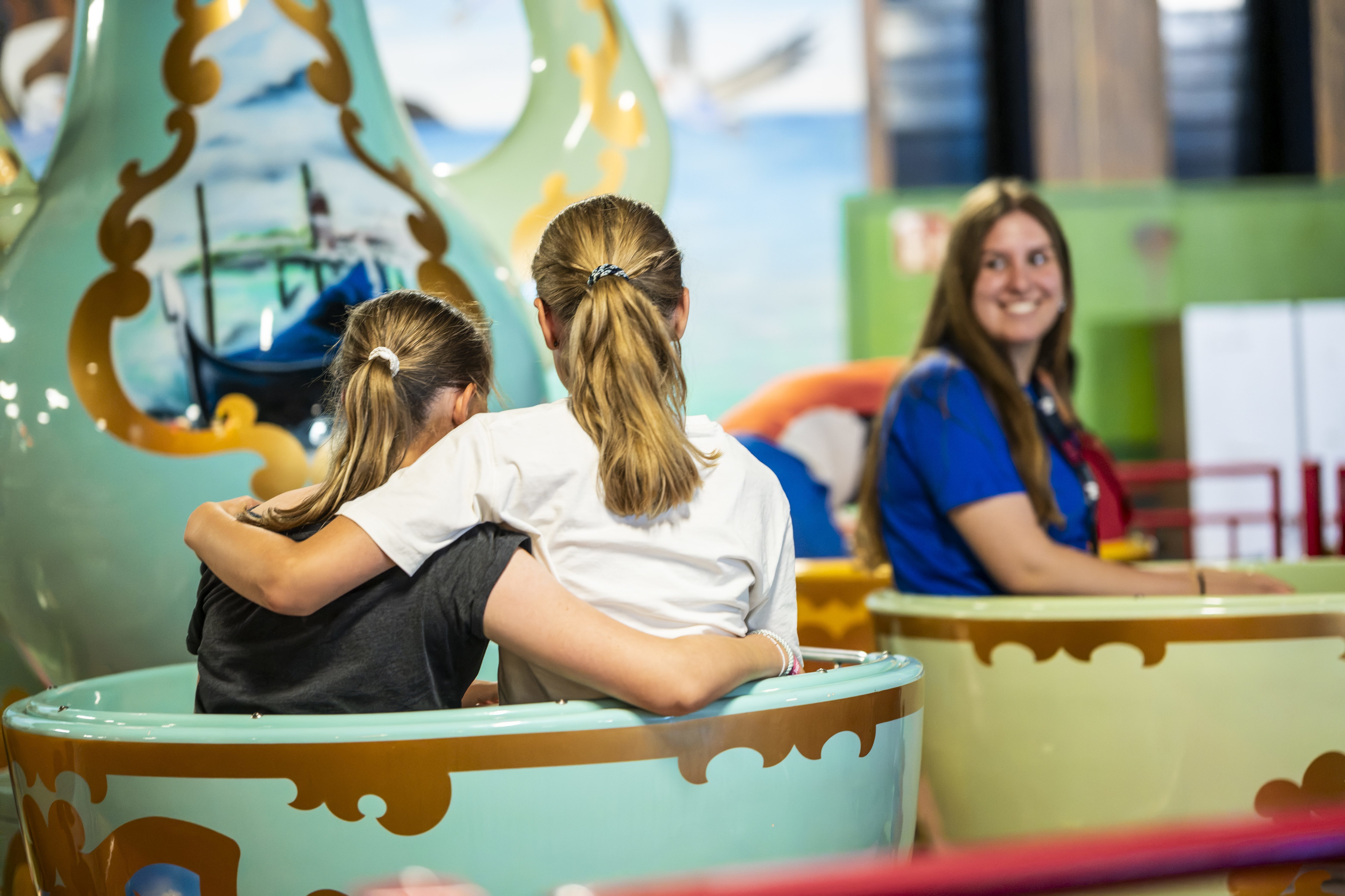 Camp guests riding a carousel in the indoor play world at Wangerland