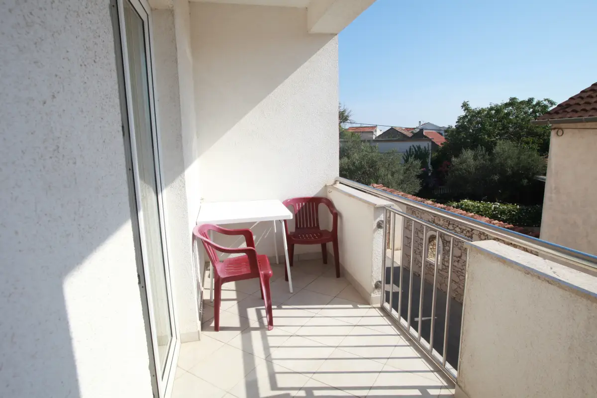 Room balcony with a table and chair looking out over Pakostane