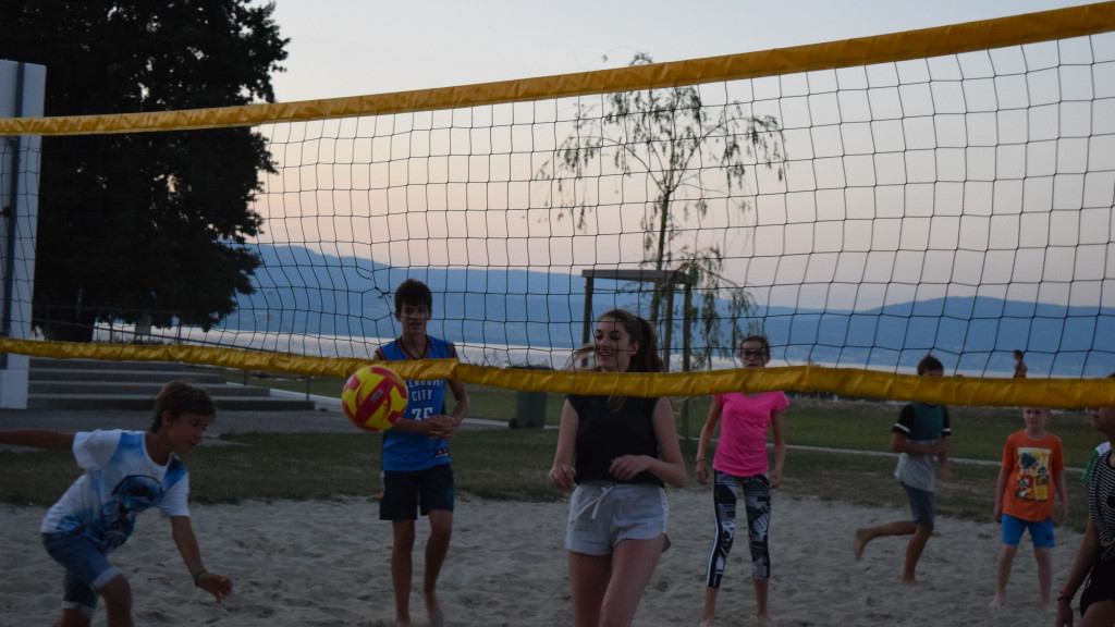 Group playing beach volleyball on the sand at the friLingue camp in Estavayer-le-Lac