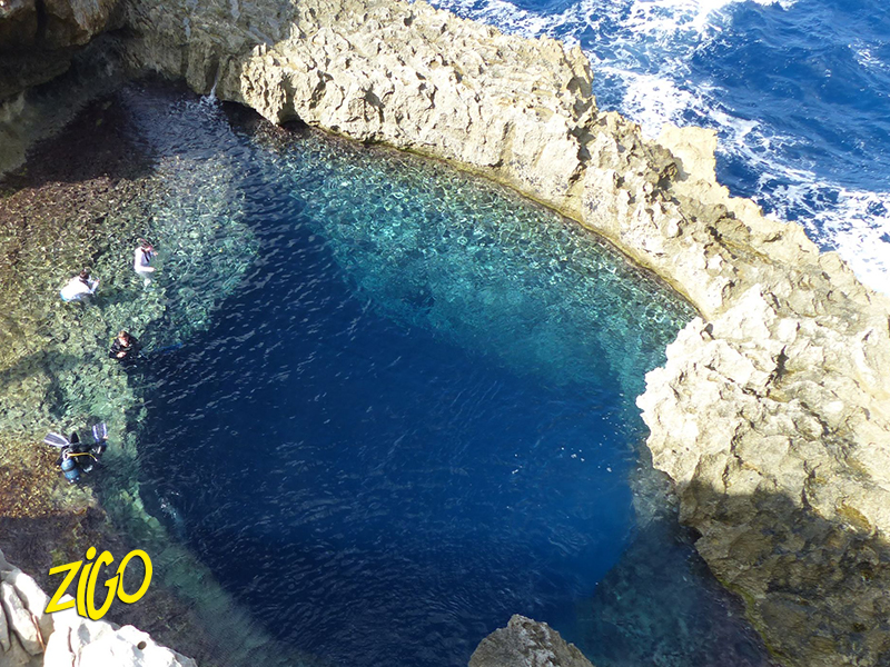 Deep blue natural sea pool set in the limestone rock of the Gozo coast