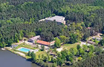 Aerial view of Kindererholungszentrum Am Braunsteich near Weisswasser with lake, pool and buildings in the forest