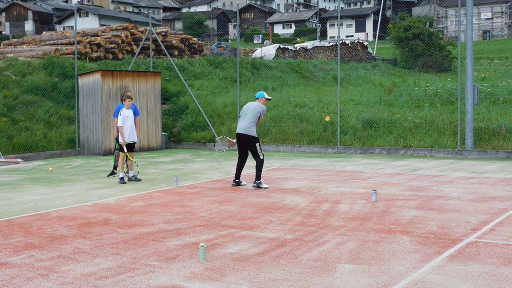 Young players on court at the tennis camp near the chalet