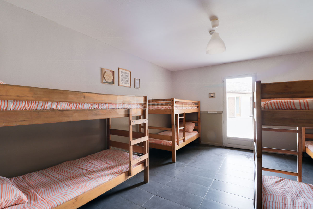 A bedroom on the estate with wooden bunk beds and made-up mattresses where the children sleep