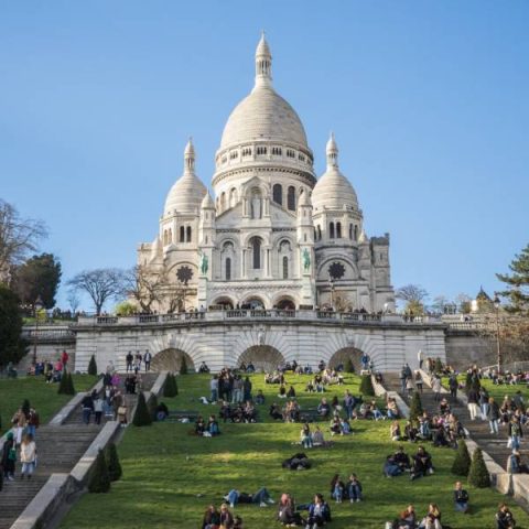 The white domes of the Sacre-Coeur basilica seen from the lawns below