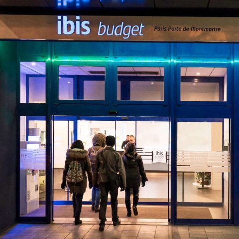 Entrance of the ibis hotel used on this trip, guests in the lit glass doorway