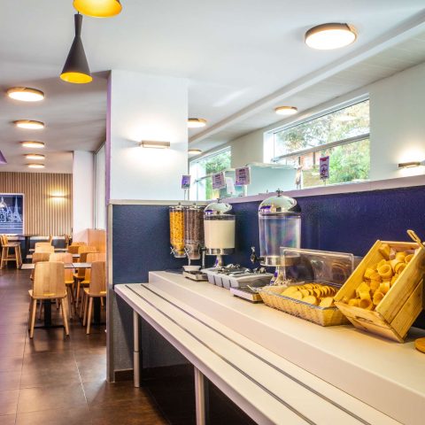 Breakfast buffet with cereal dispensers, fruit and bread in the hotel breakfast room