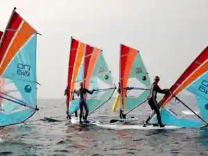 Group of young windsurfers on the water with the surf school at Schubystrand