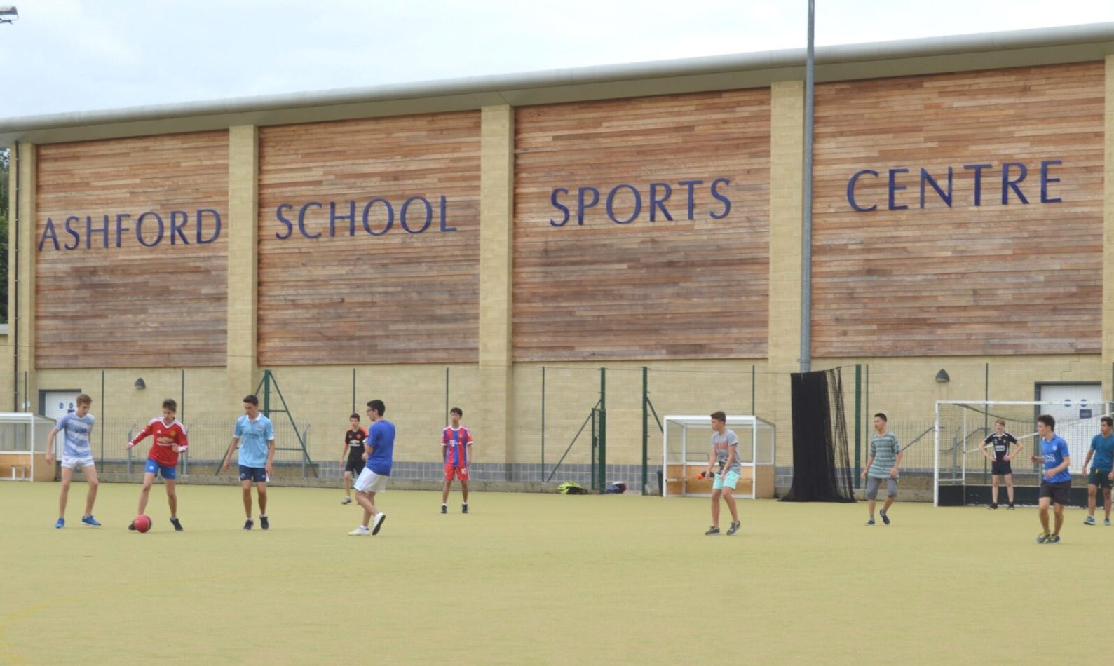 Children playing football on the astro turf in front of the Ashford School Sports Centre, Ashford, Kent