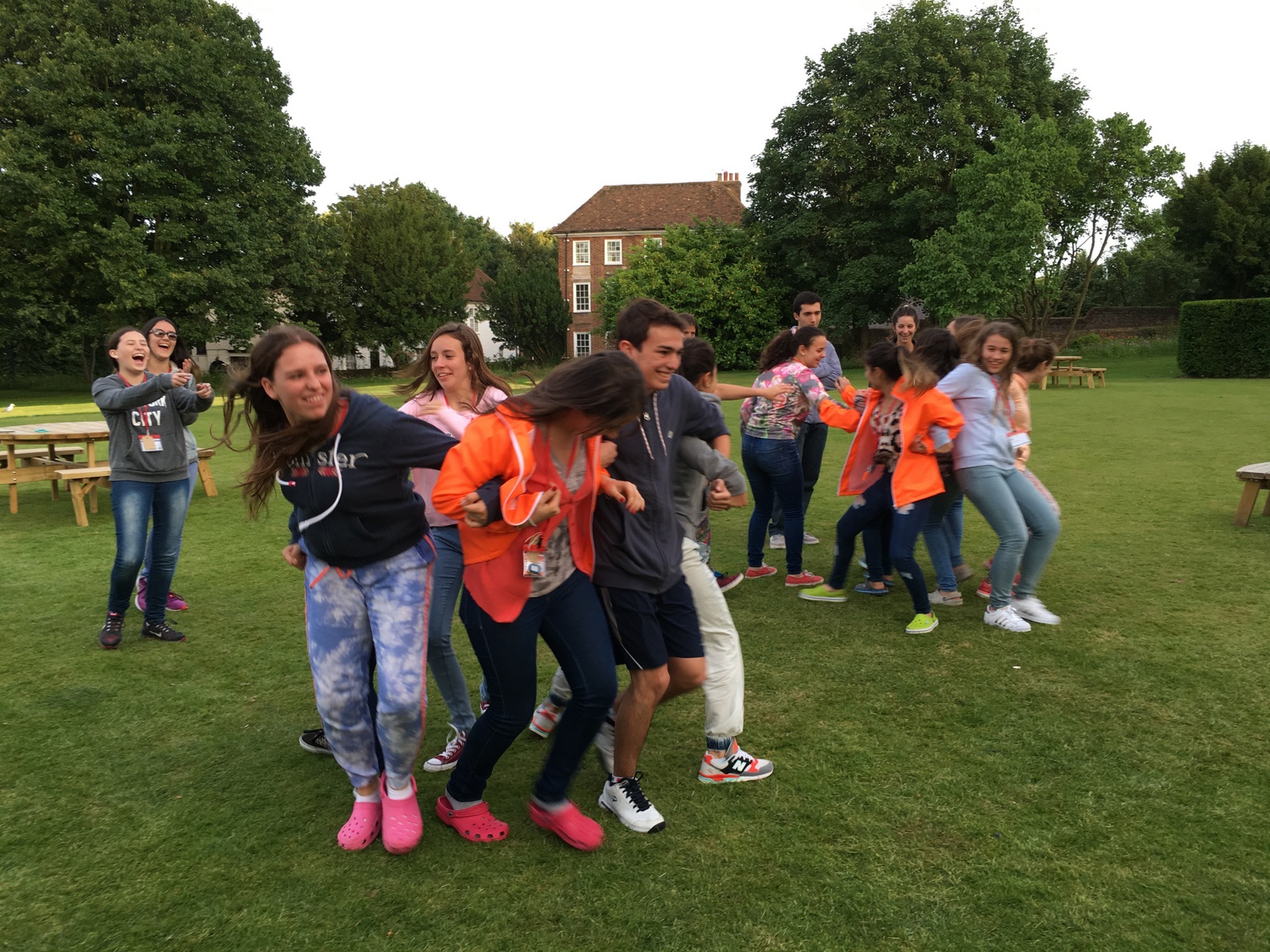 Summer school students playing a team game on the lawn by the picnic tables at Ashford School, Ashford, Kent