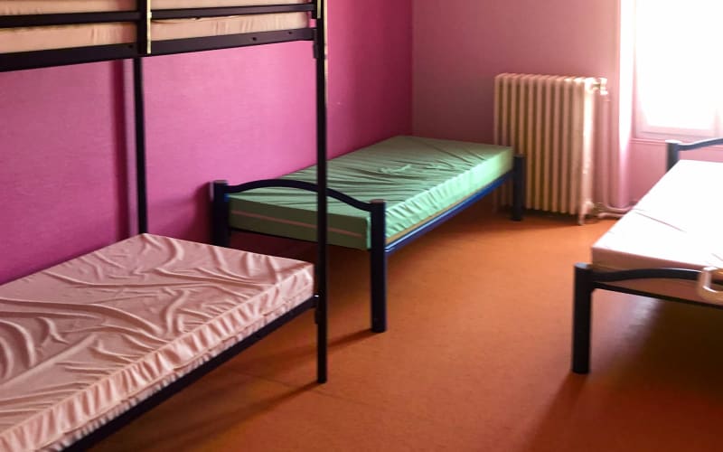 A bedroom at the centre with a bunk bed, a radiator and a partition wall