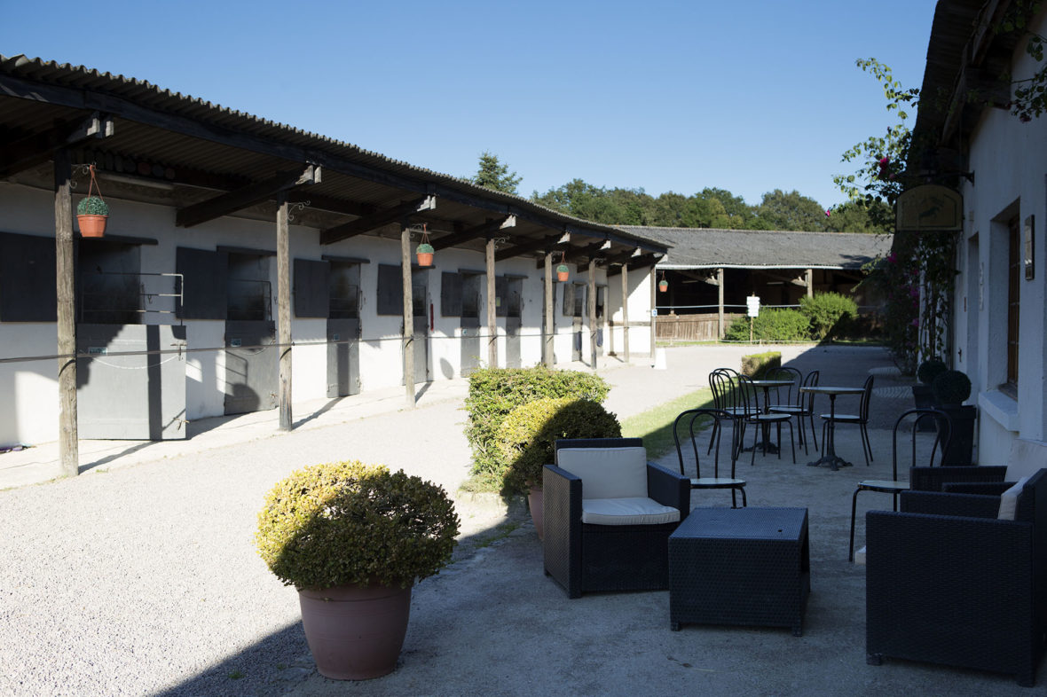 A covered terrace and club house beside the stable buildings