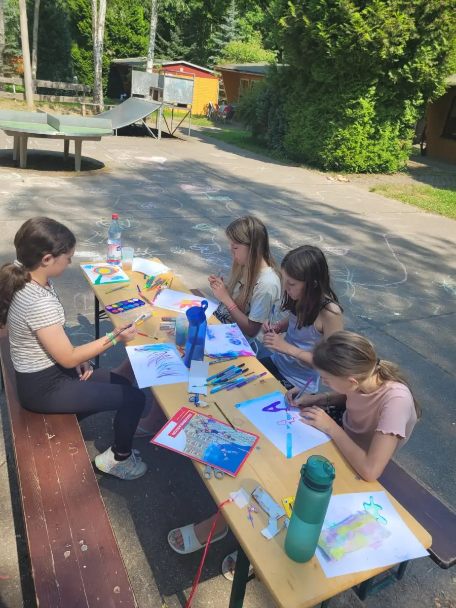 Girls painting at an outdoor table