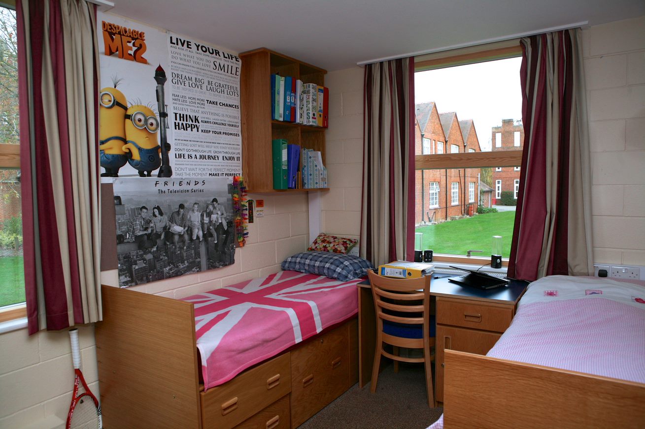 Twin bedroom in a Culford boarding house with two beds, a desk and a window onto the grounds