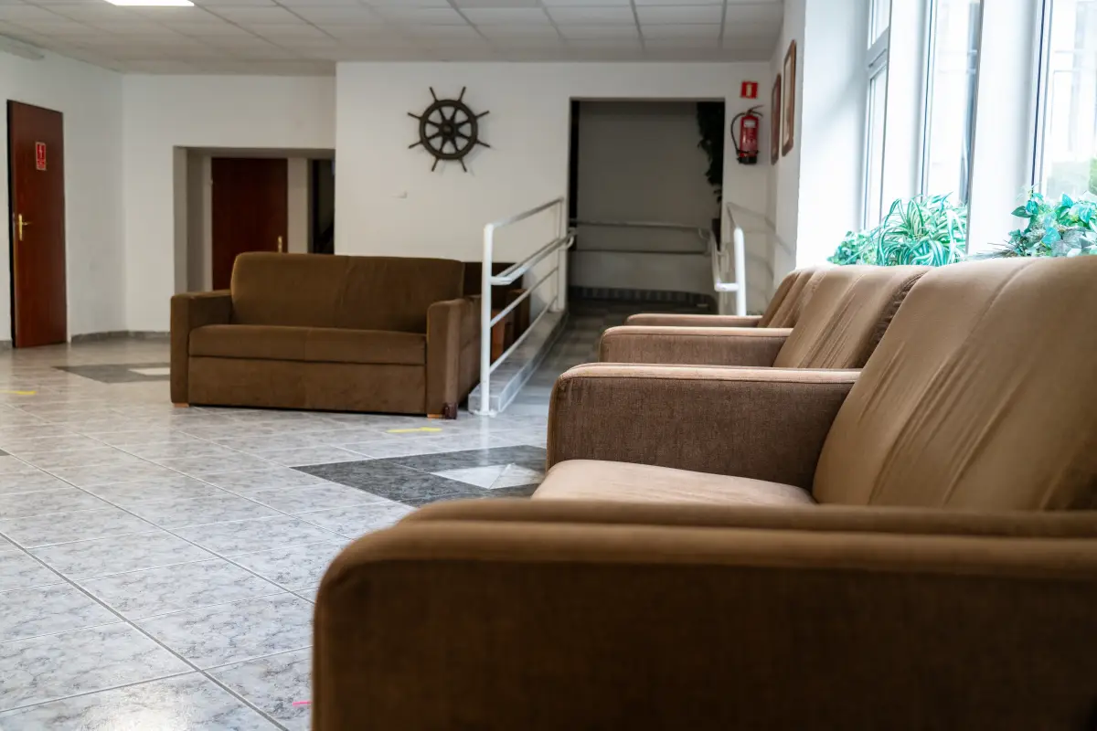 A lounge area with sofas and armchairs in the common room of the complex
