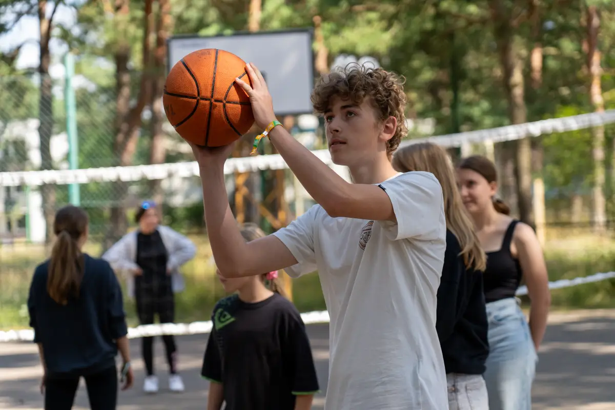 Campers playing basketball on the outdoor court at the holiday complex
