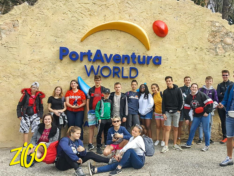 Group of young people gathered under the PortAventura World sign at the park entrance