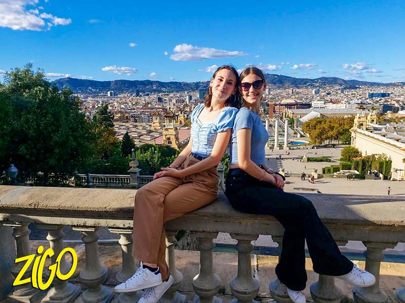 Two participants sitting on a stone balustrade with Barcelona spread out behind them