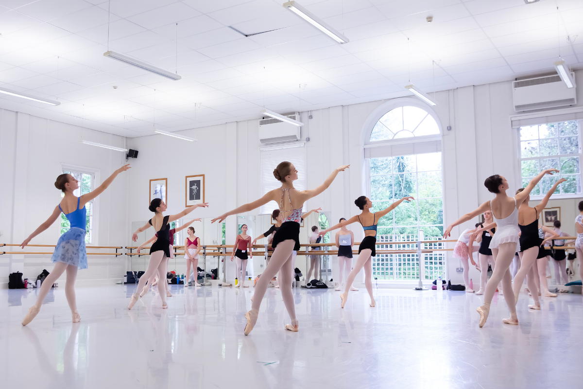 Intensive course students dancing in a bright, high-ceilinged ballet studio