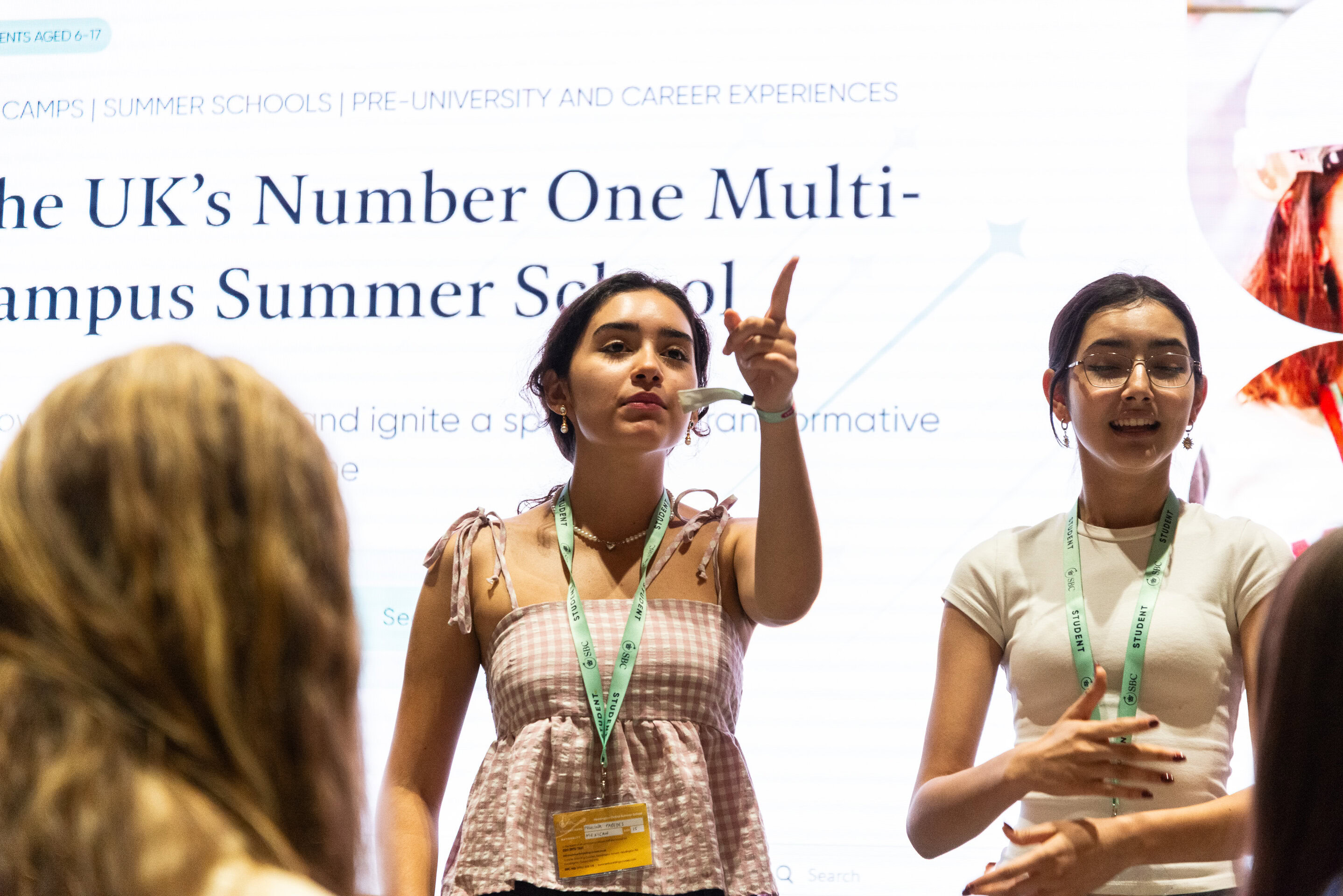 Two students present in front of a screen during a Summit session
