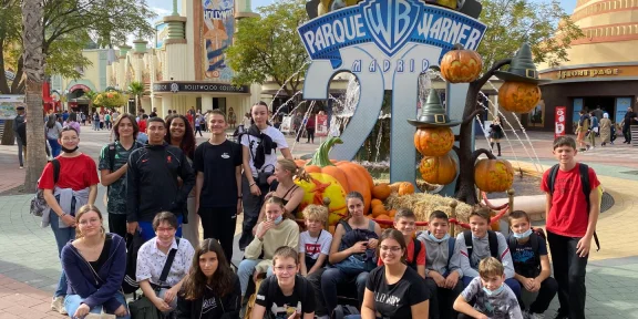 Group in front of the Parque Warner Madrid entrance sign decorated with pumpkins