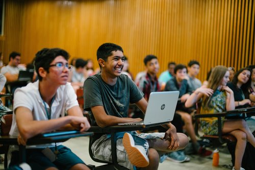 Summer programme students sitting at desks with laptops, listening during a class in a Georgetown teaching room