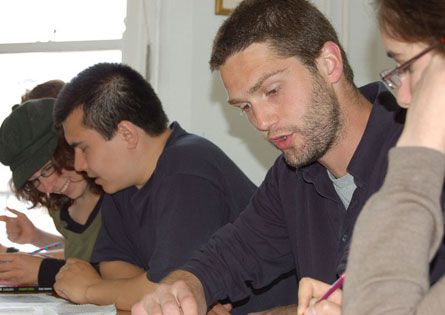 Students and a teacher working together in a classroom at LSI Cambridge