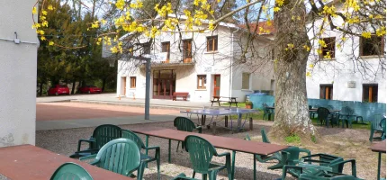 The main building of the Tour de Buis centre with outdoor tables under the trees