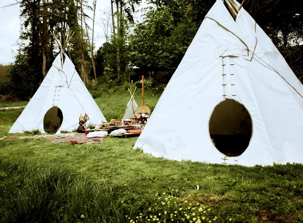 Two tipis and the campfire area on the lawn at the Tour de Buis centre
